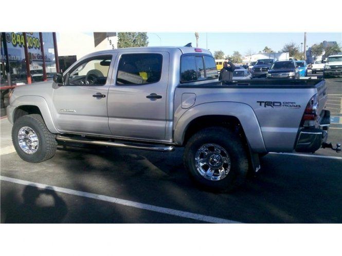 A silver tacoma truck is parked in a parking lot