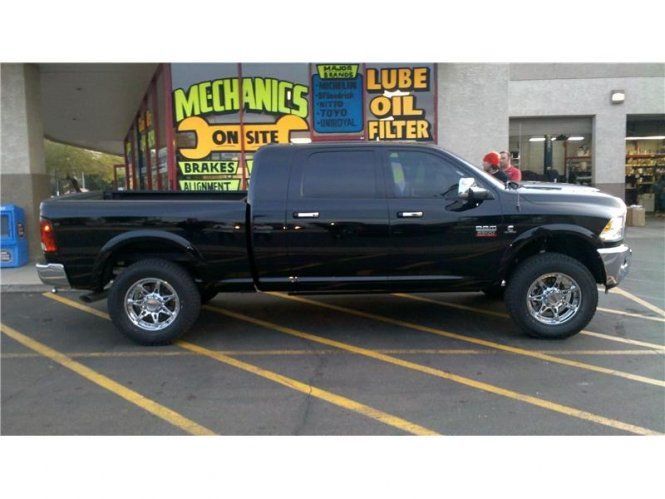 A black truck is parked in front of mechanics on site
