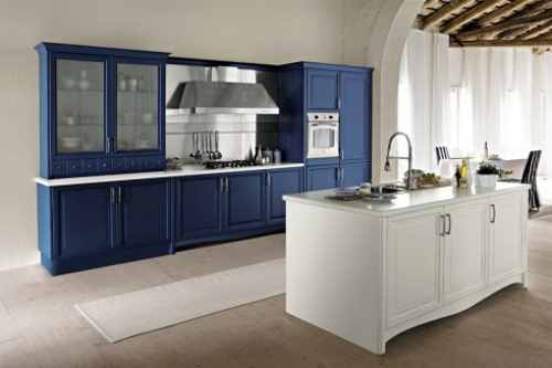 una cucina con mobili blu e penisola con mobili bianchi