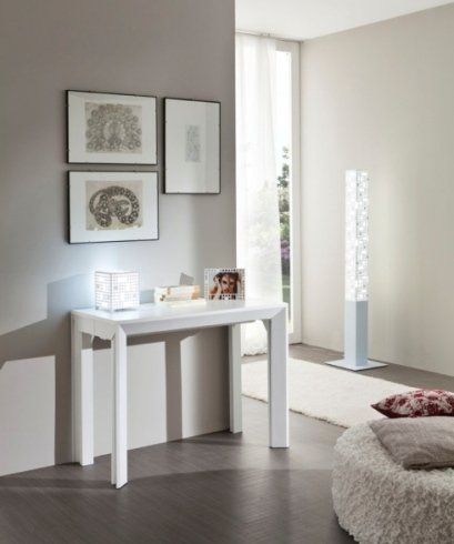 un tavolino bianco con sopra delle cornici e dei quadri al muro