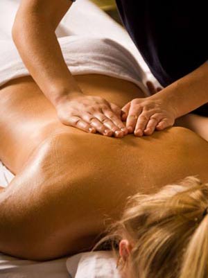 A woman is getting a massage on her back at a spa.