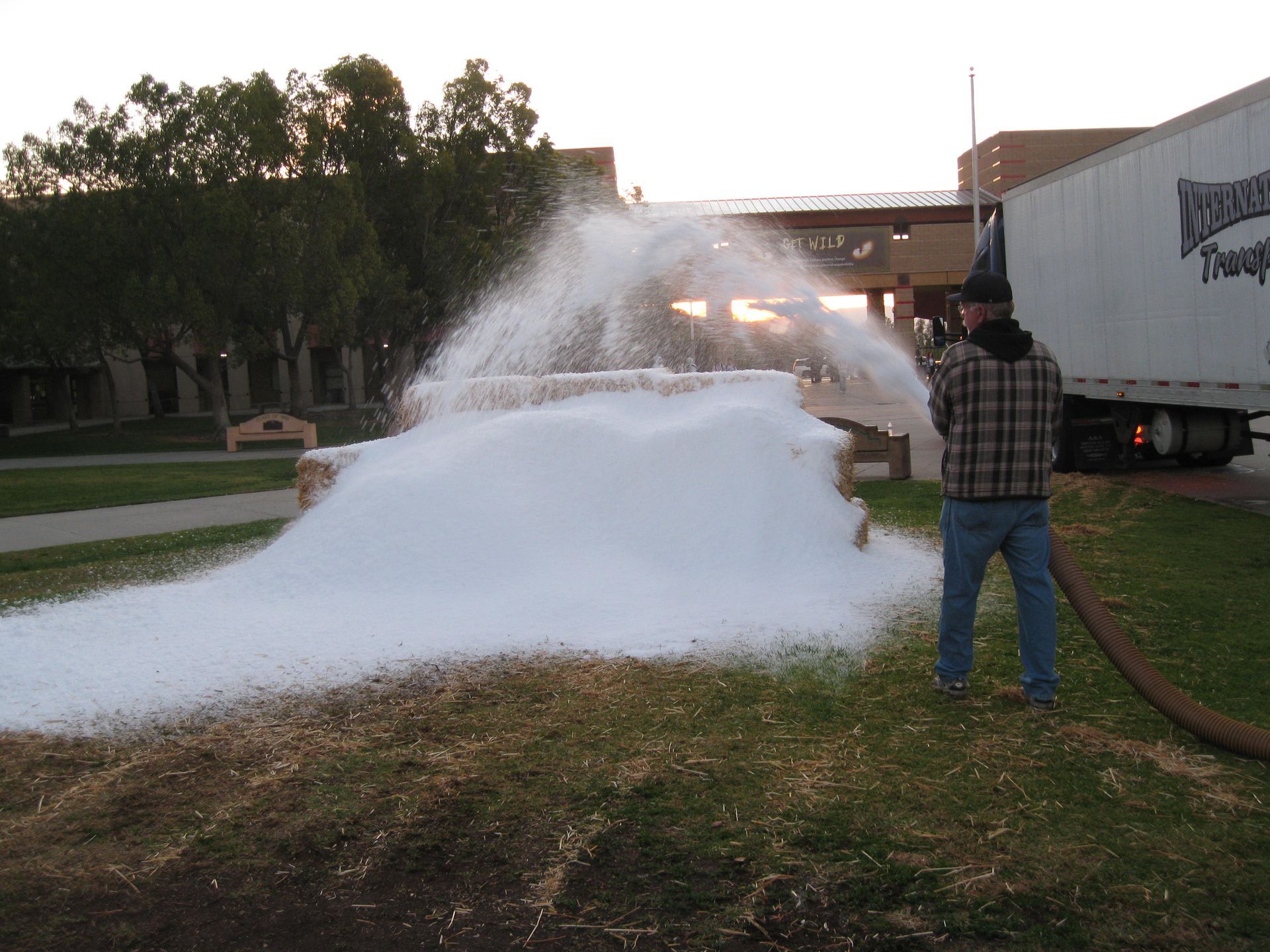 A man is standing in front of a large pile of foam