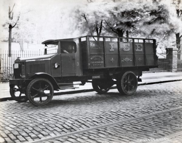 A man is sitting on the back of a mountain view ice delivery truck.