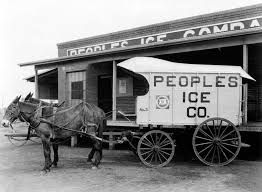 A horse drawn wagon is parked in front of a building.