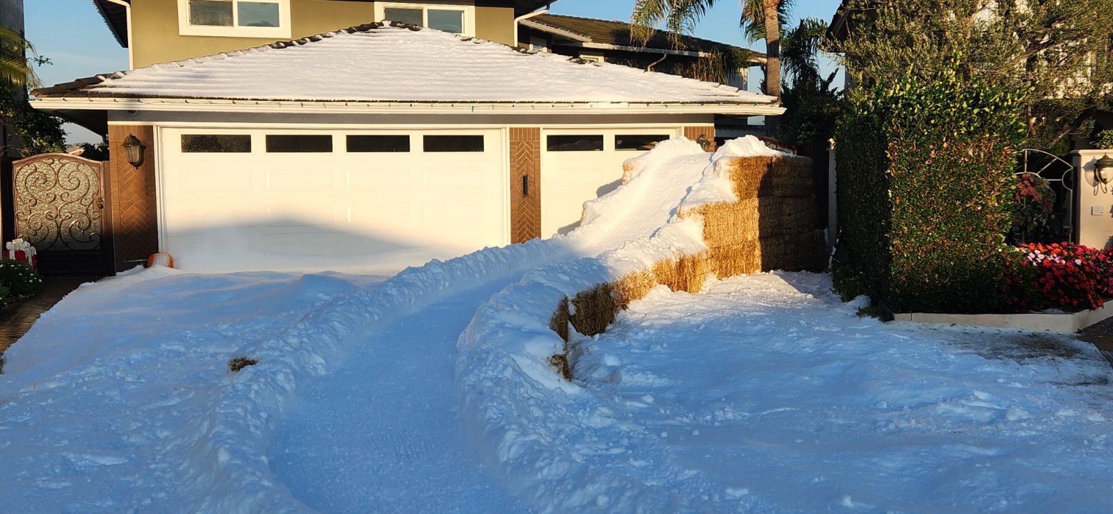 A house with a garage and driveway covered in snow.