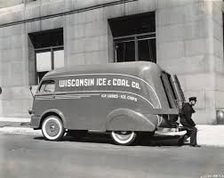 A black and white photo of a wisconsin ice and coal truck parked in front of a building.