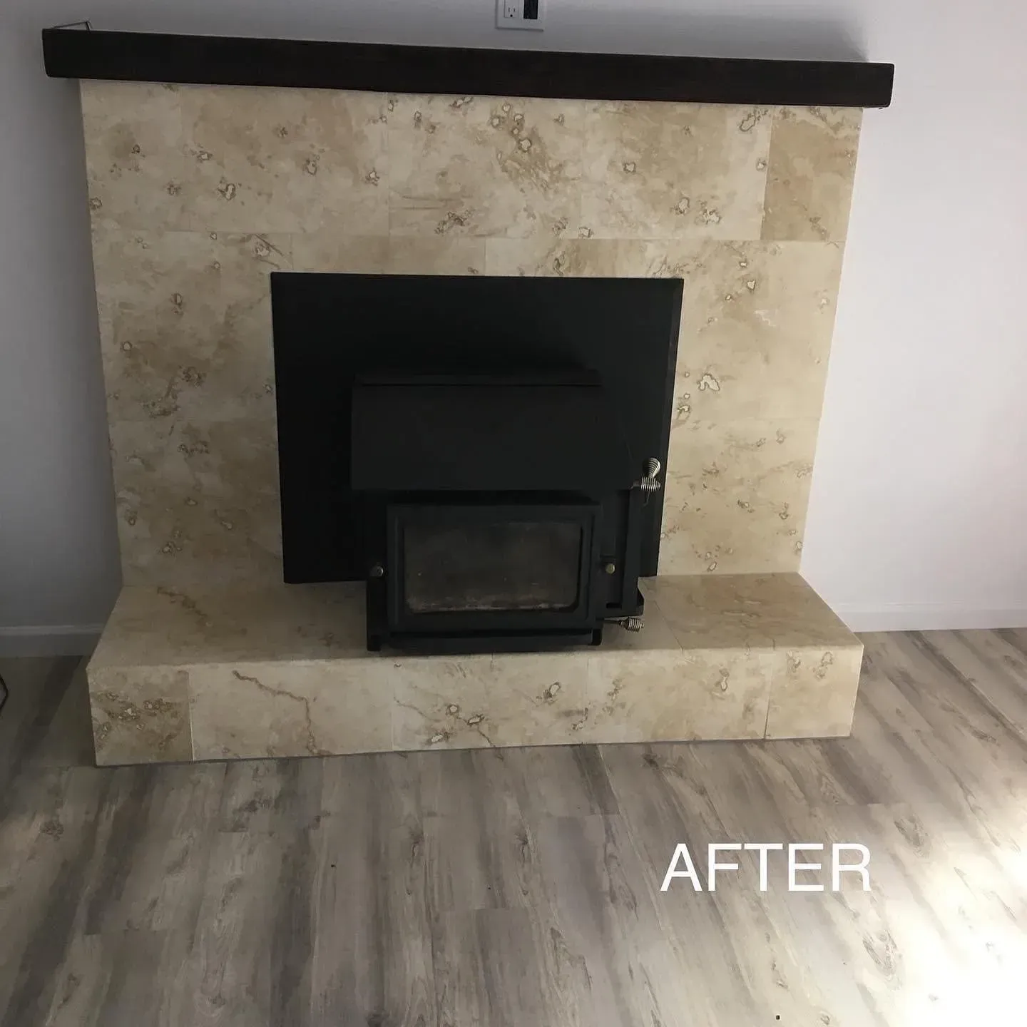 Beige stone fireplace with a black insert in a light wood-floored room, labeled “AFTER”