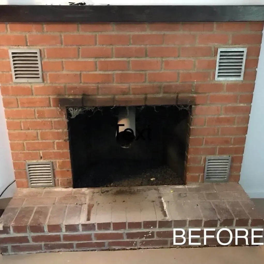 Brick fireplace opening with black interior and metal vents on both sides, labeled “BEFORE”