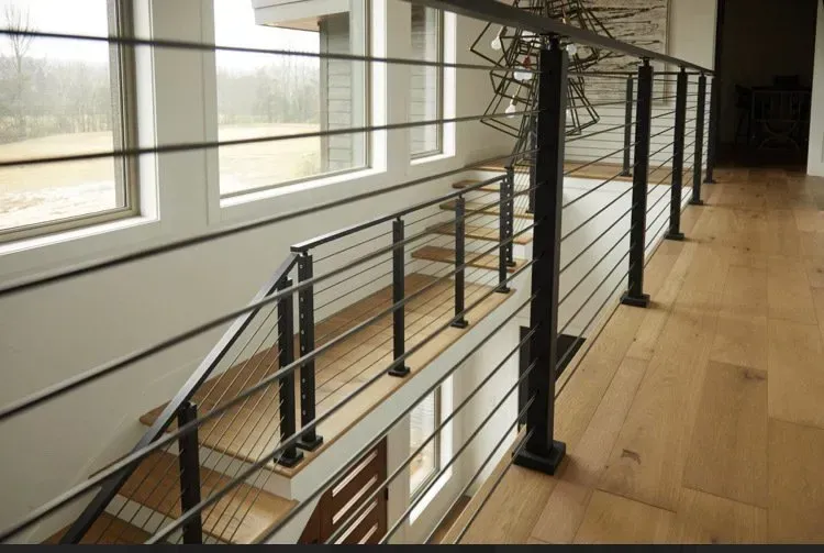 Modern indoor staircase with metal railings and wooden floor in a bright hallway