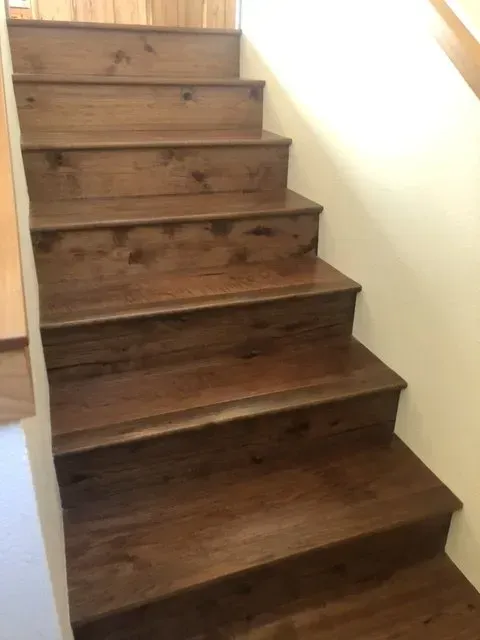 Wooden indoor staircase with six steps and white walls beside it