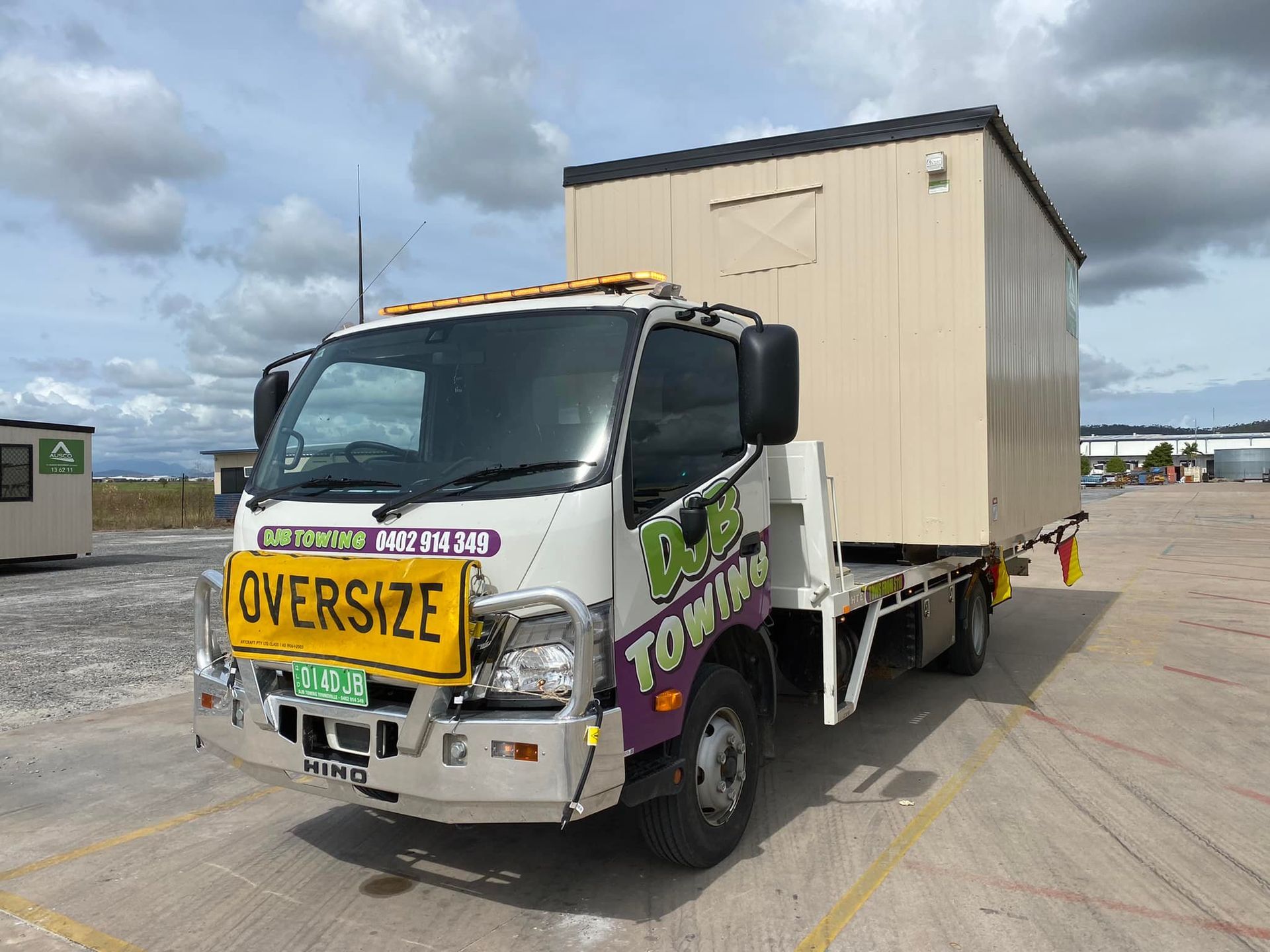 A Truck Is Driving Down a Highway with A Car on The Back of It — Hot Shots 2 U In Townsville, QLD