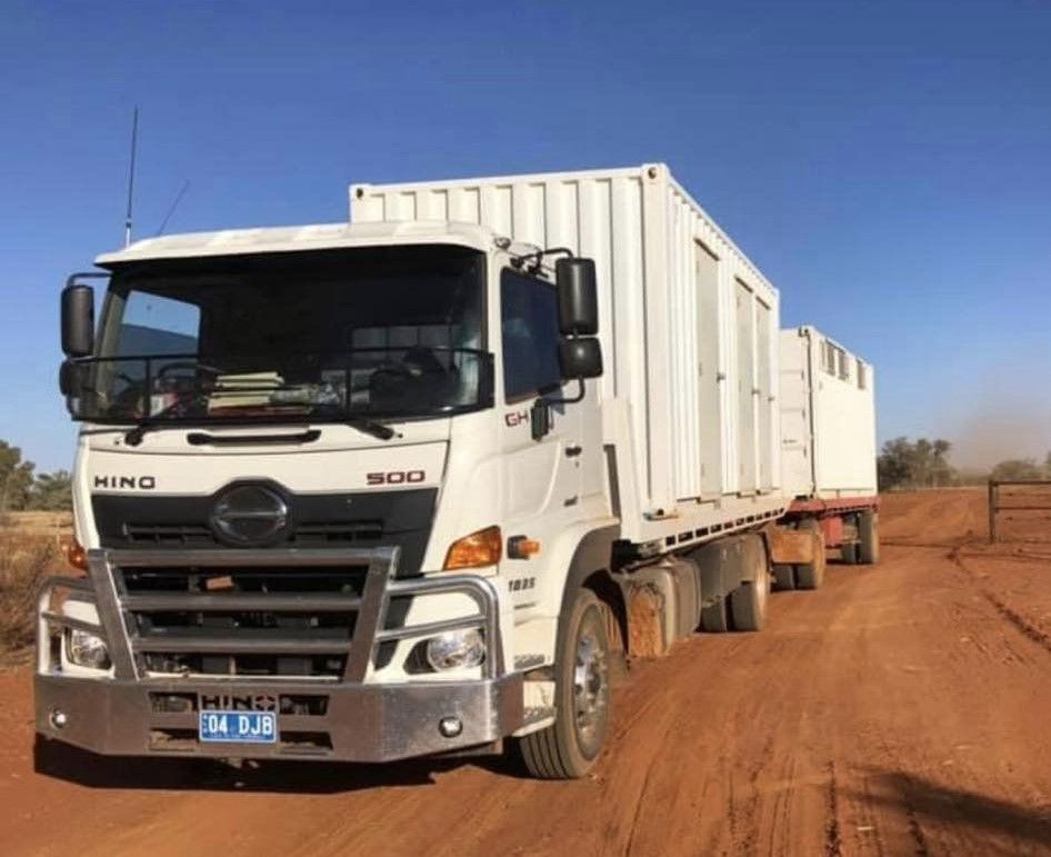 White Hino Truck With Container on a Dirt Road in a Sunny, Rural Setting — Hot Shots 2 U In Townsville, QLD