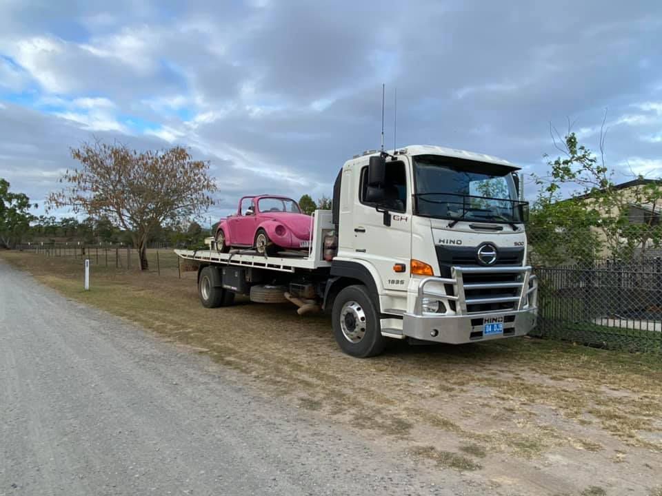 A Pink Volkswagen Beetle is Loaded Onto a White Hino Tow Truck — Hot Shots 2 U In Townsville, QLD