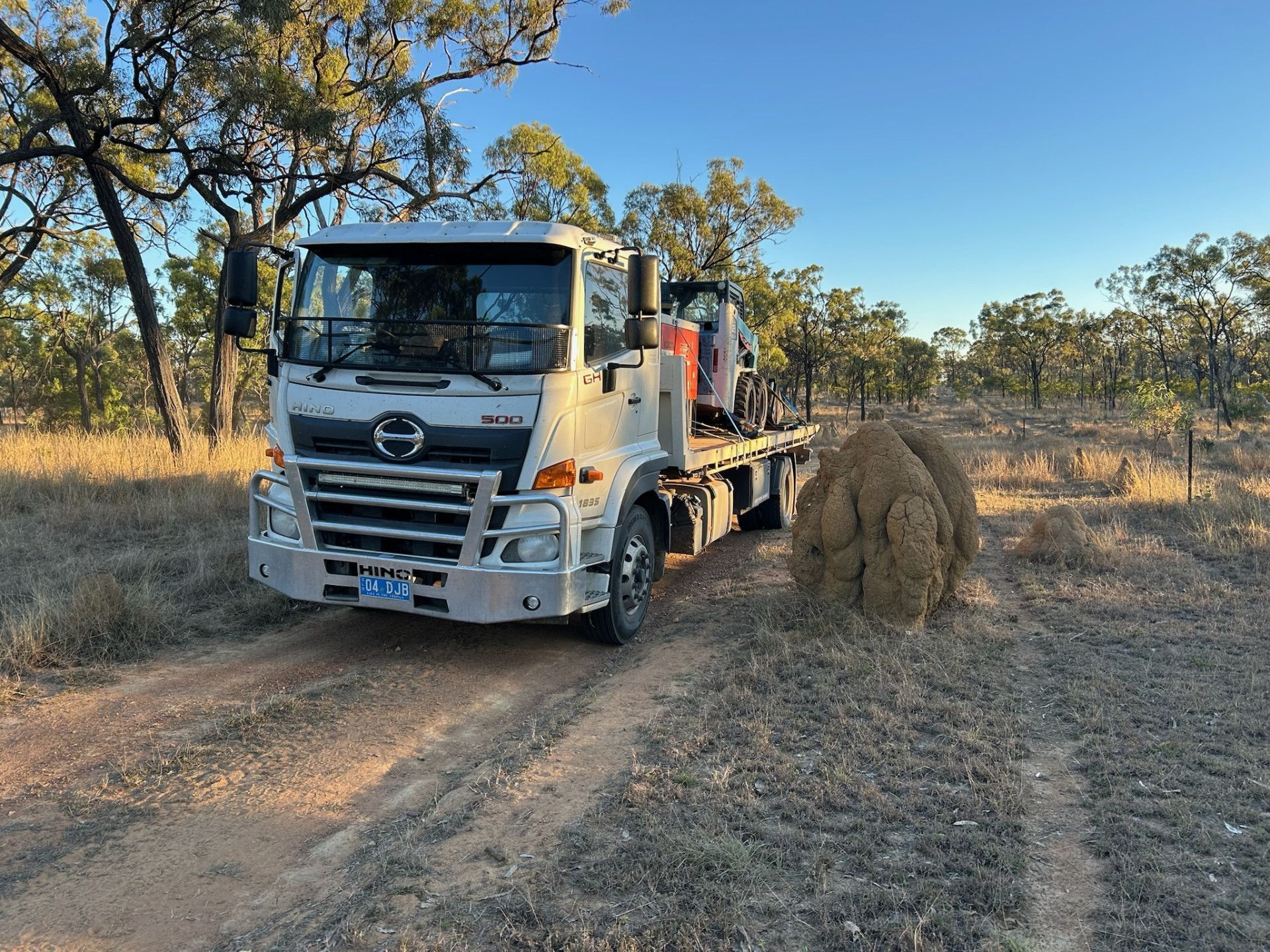 Hino Truck Hauling Equipment in a Dry, Grassy Field — Hot Shots 2 U In Townsville, QLD