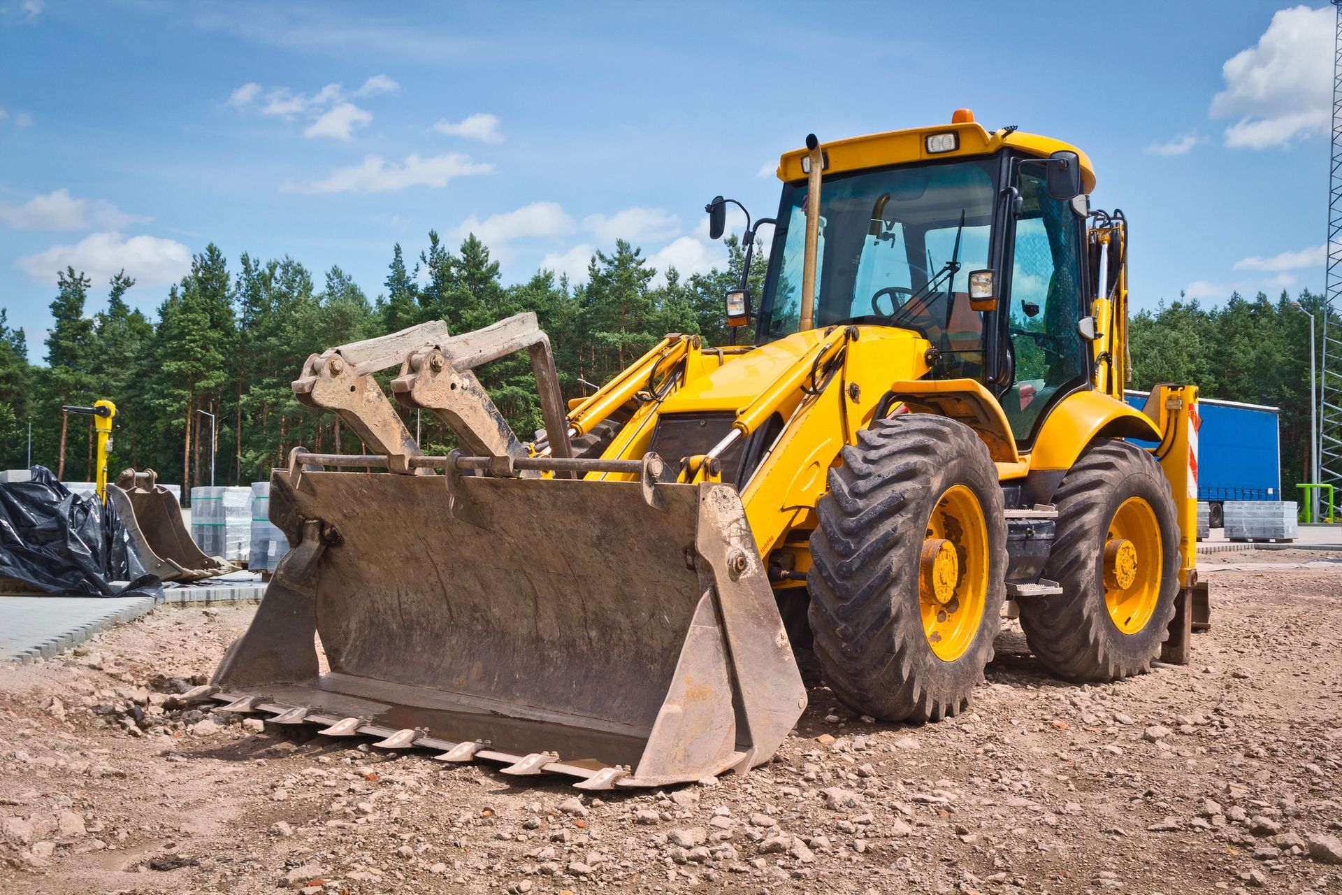 A yellow bulldozer is sitting on top of a dirt field.