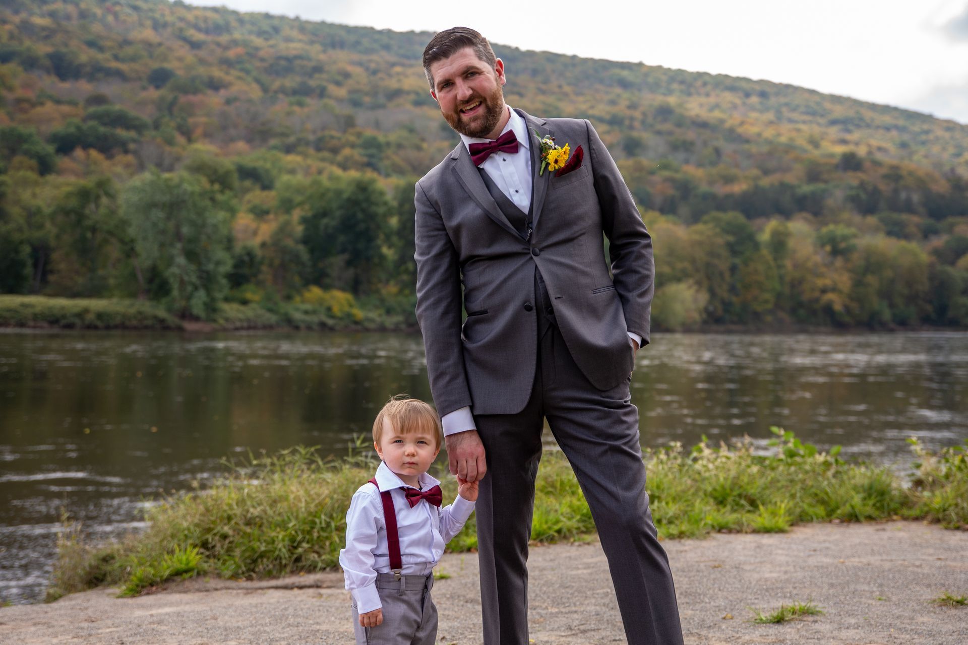 A photo of a man in a suit  standing next to a little boy in a bow tie taken by Ever After Studio.