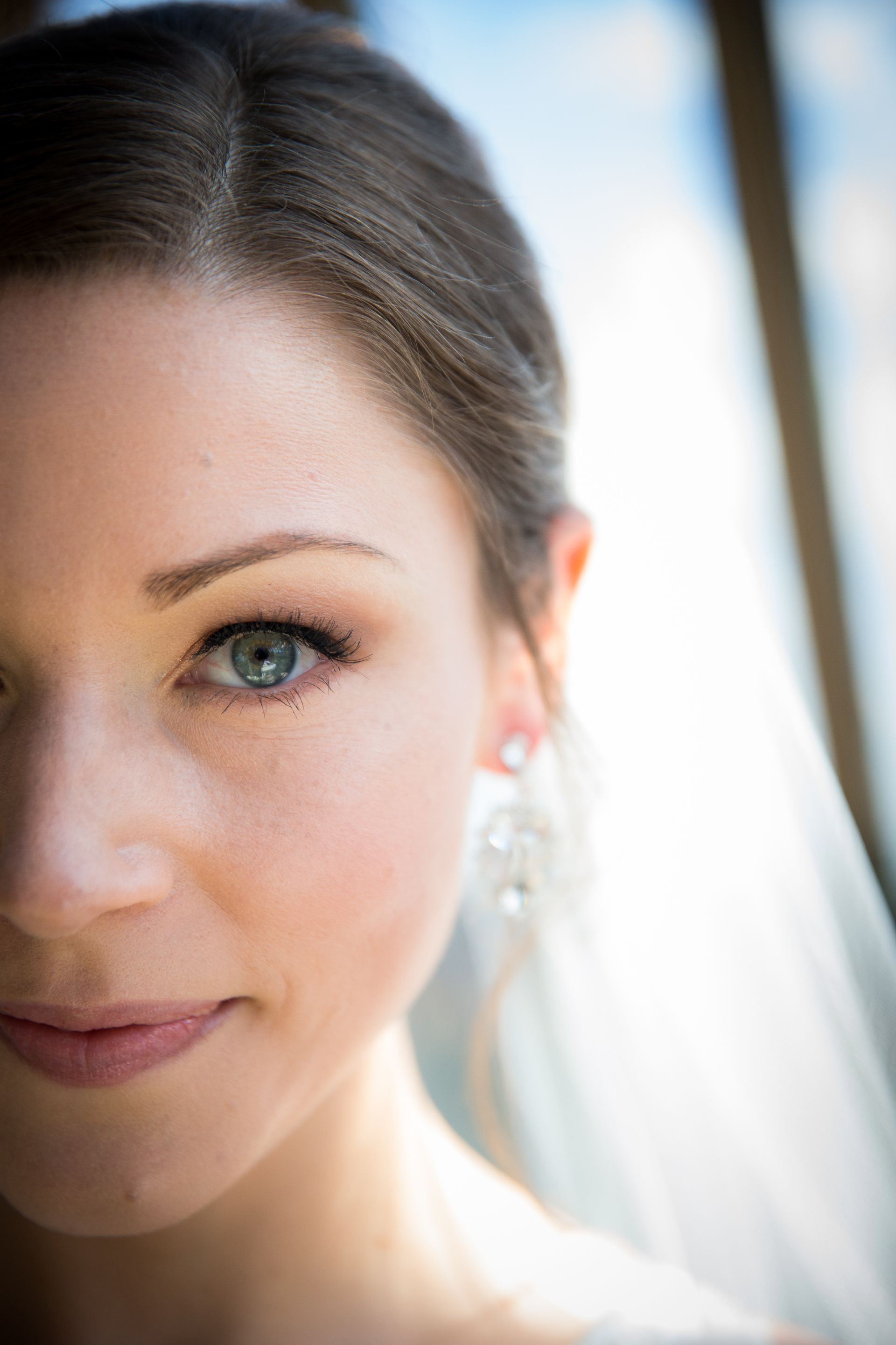 A close up of a woman 's face with a veil on taken by Ever After Studio.