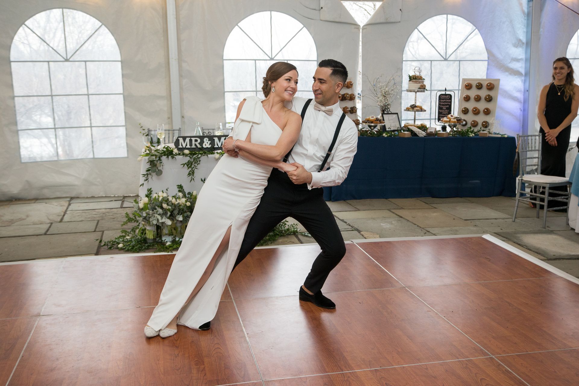 A bride and groom are dancing on a wooden dance floor taken by Ever After Studio.