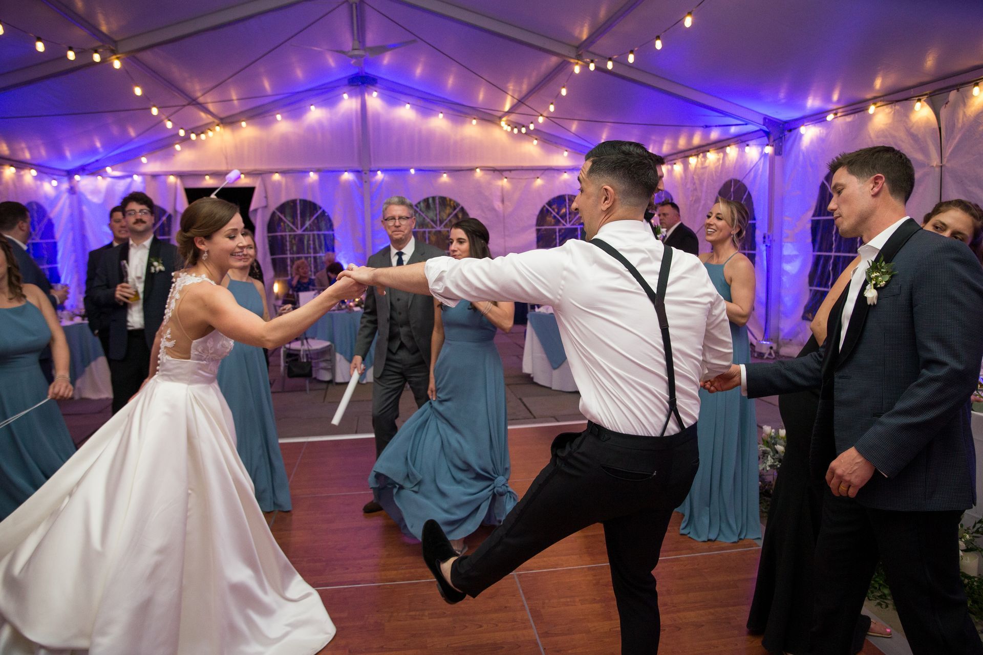 A bride and groom are dancing in a tent at their wedding reception taken by Ever After Studio.