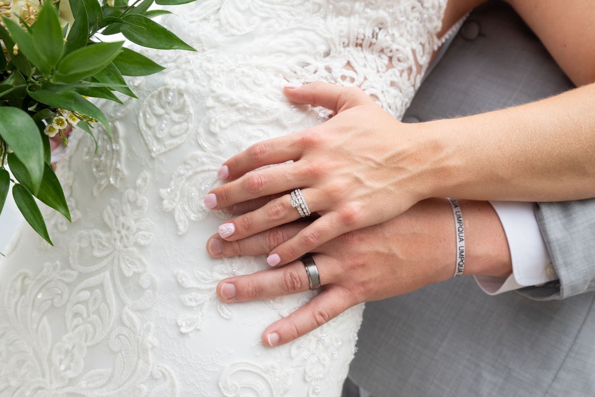 A close up of a bride and groom 's hands with wedding rings taken by Ever After Studio.
