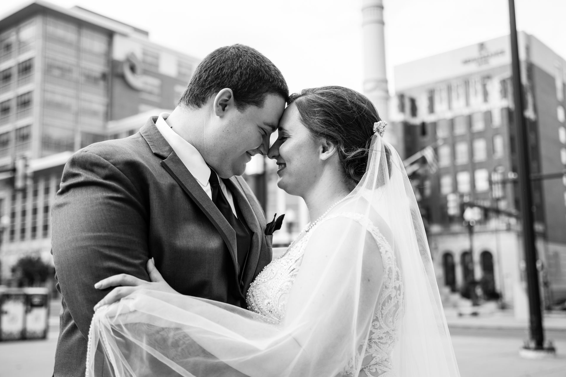 A black and white photo of a bride and groom looking into each other 's eyes taken by Ever After Studio.