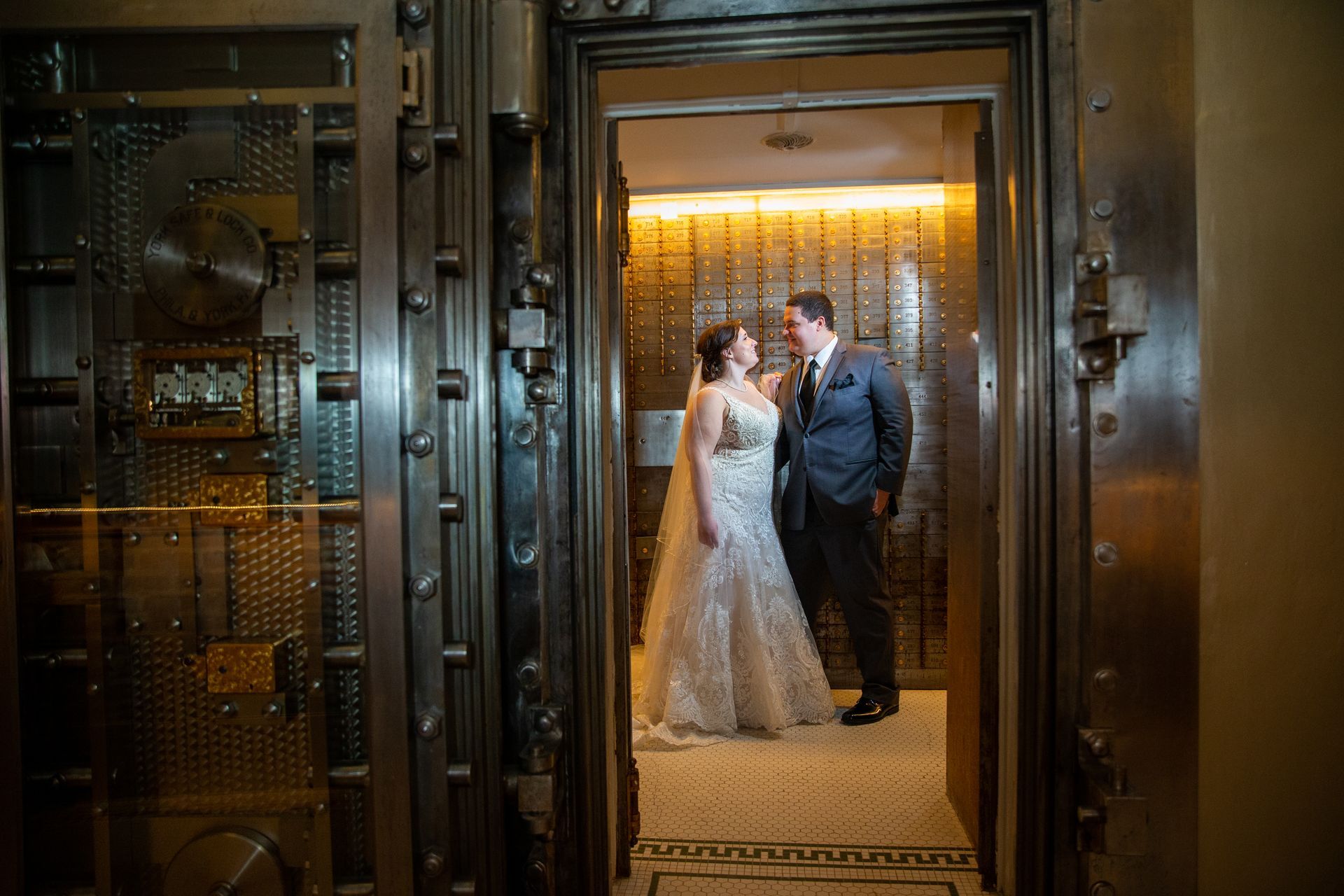 A bride and groom are posing for a picture in a vault taken by Ever After Studio.