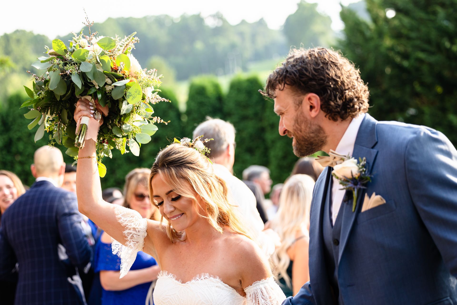 A bride and groom are walking down the aisle at their wedding taken by Ever After Studio.