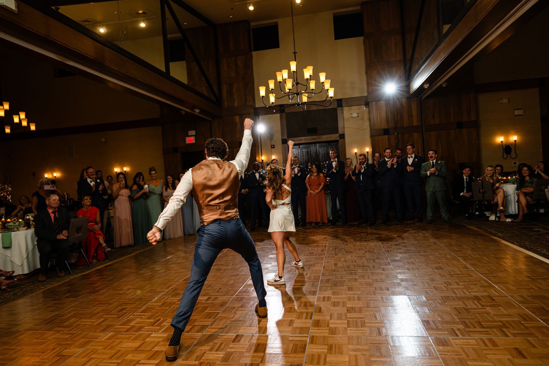 A bride and groom are dancing on a wooden dance floor at their wedding reception taken by Ever After Studio.