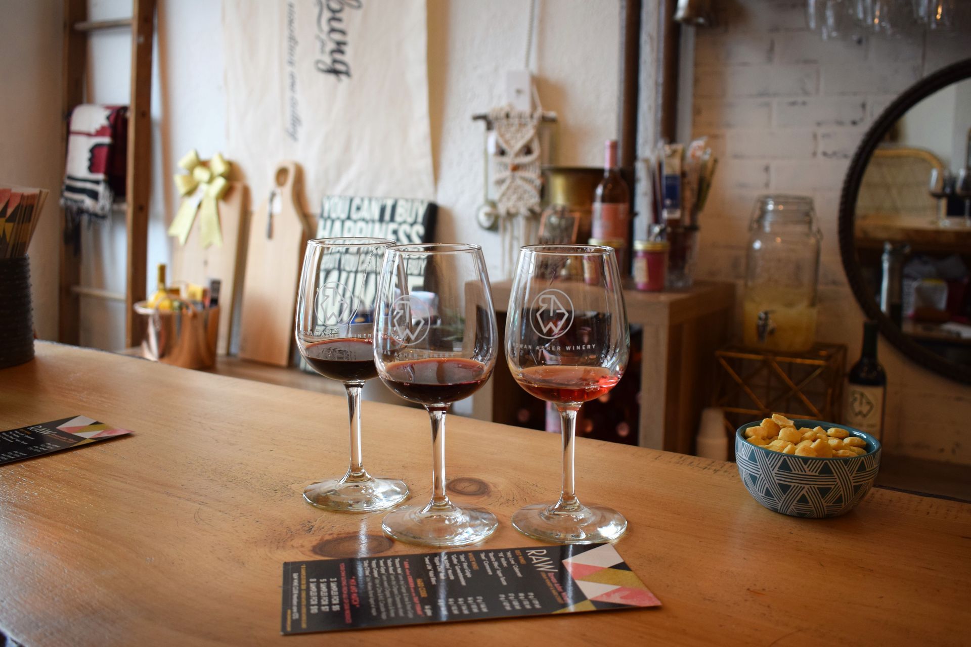 Two glasses of wine are sitting on a wooden table Raw Urban Winery & Hard Cidery