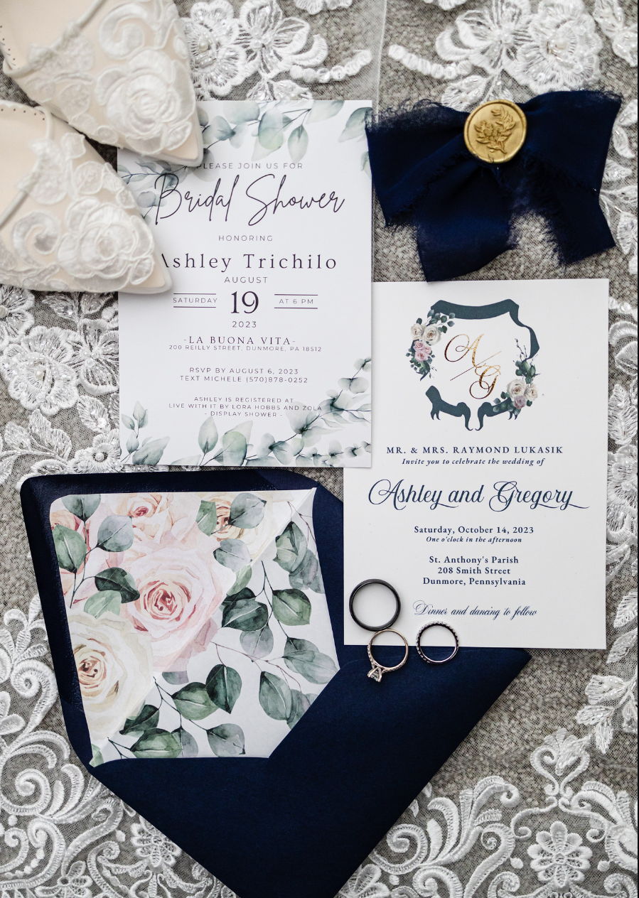 A wedding invitation and envelope are sitting on a table taken by Ever After Studio.