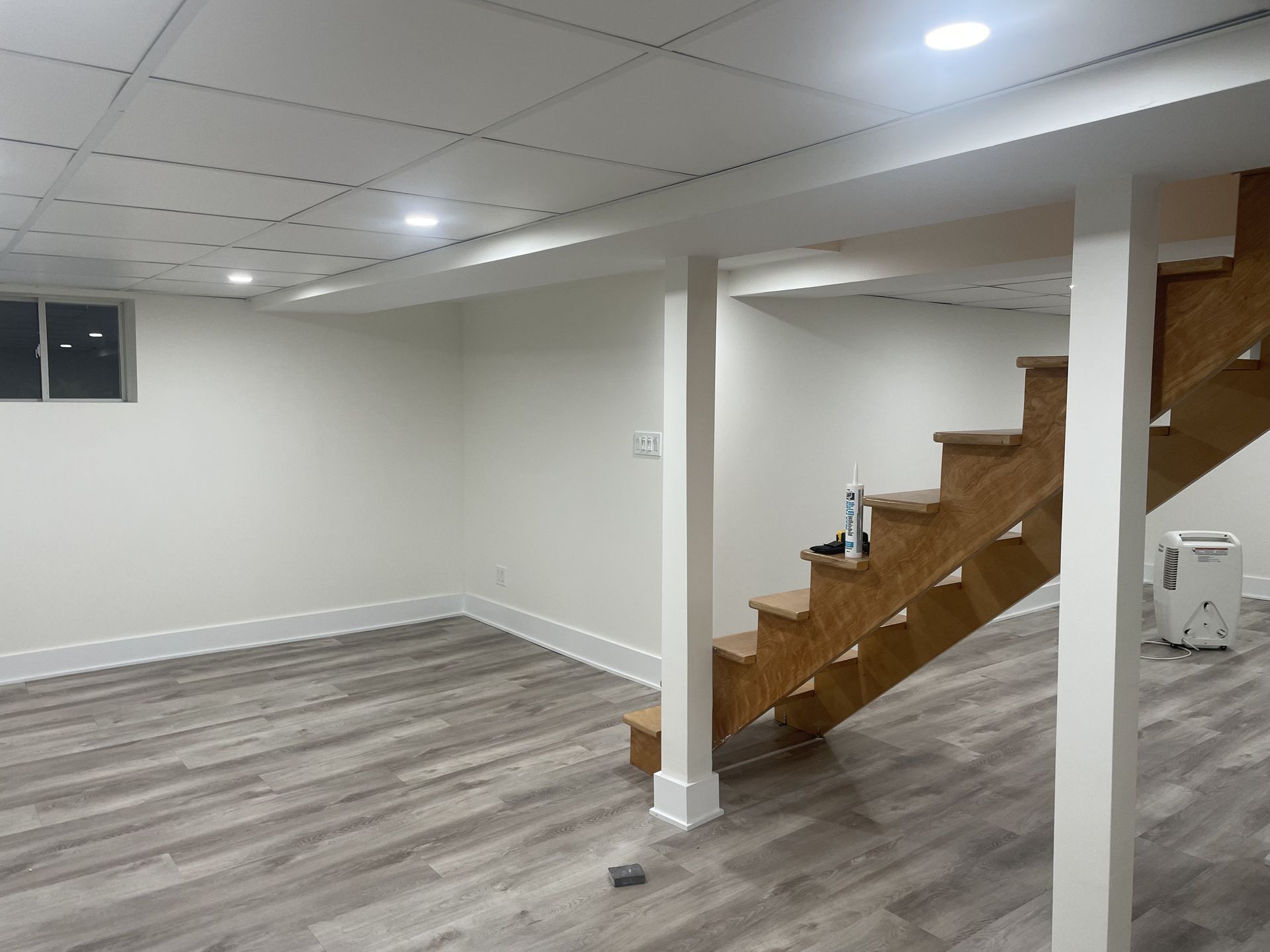 A basement with a wooden staircase leading up to the second floor.