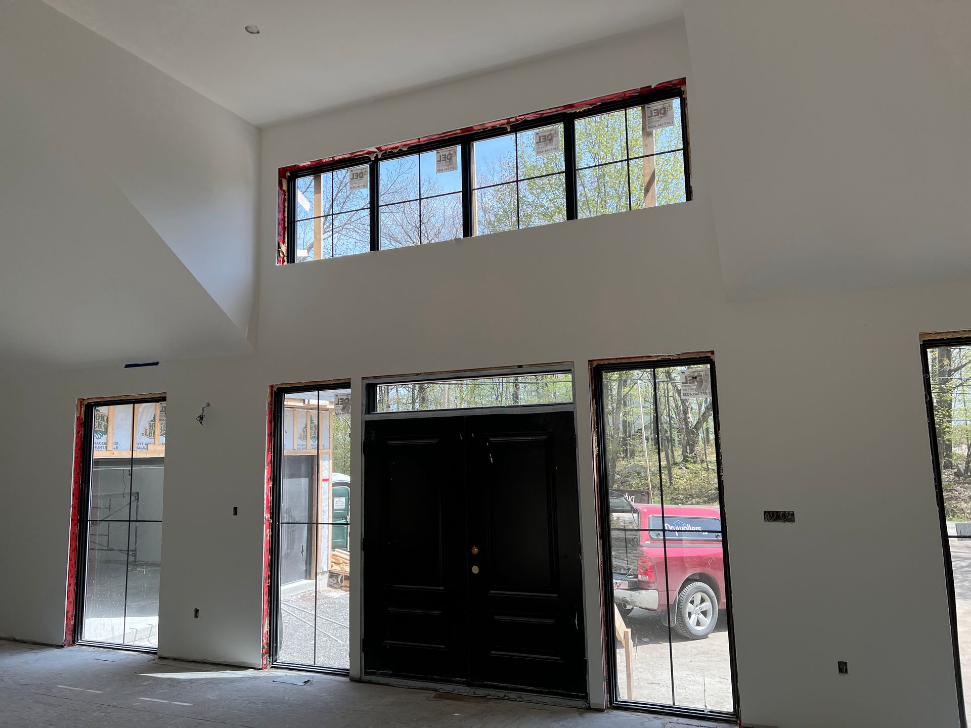 A large room with a lot of windows and a red truck parked in the background.