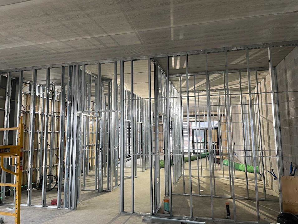 Metal stud framing for interior walls in a construction site. Concrete ceiling visible.