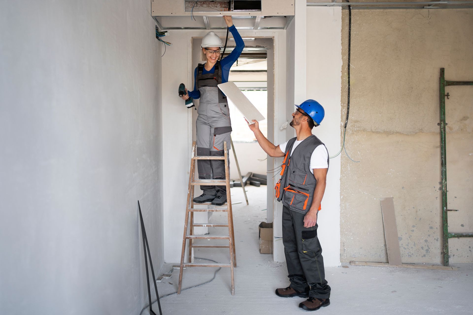 A man is standing next to a woman on a ladder.
