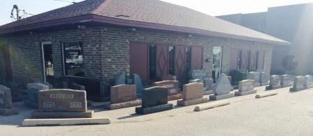 Low brick building with a covered walkway and benches outside on a sunny day