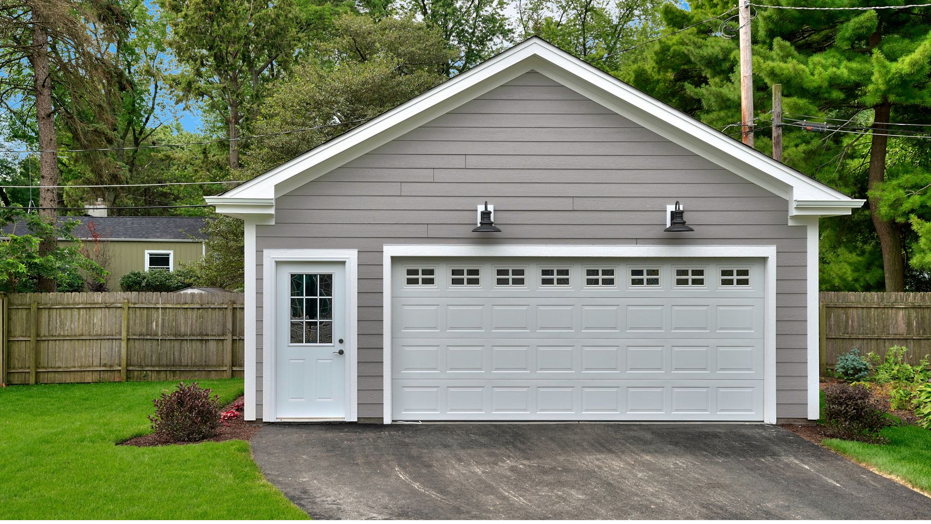 A garage with a white door and a driveway in front of it.