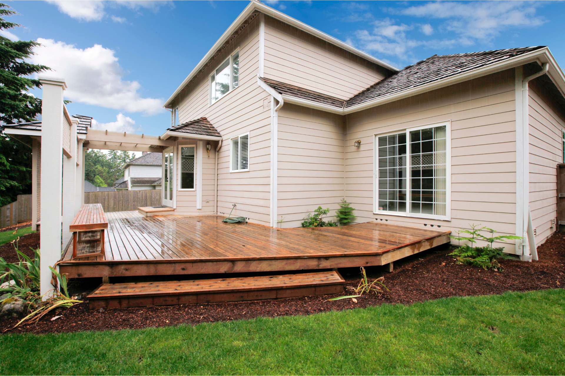 A house with a large wooden deck in front of it