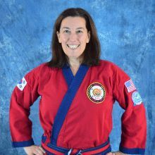 a woman is wearing a red and blue karate uniform and smiling .