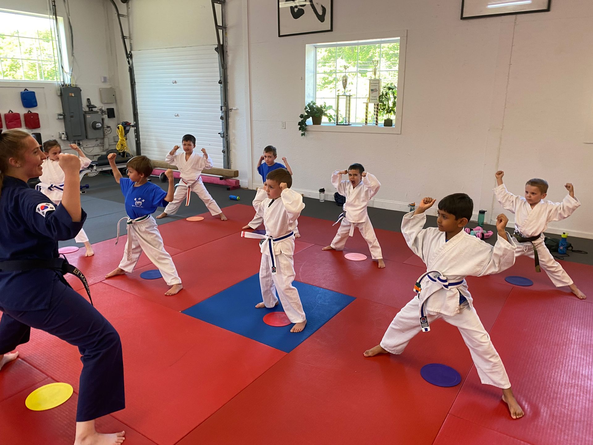 a young girl is practicing taekwondo in a gym .