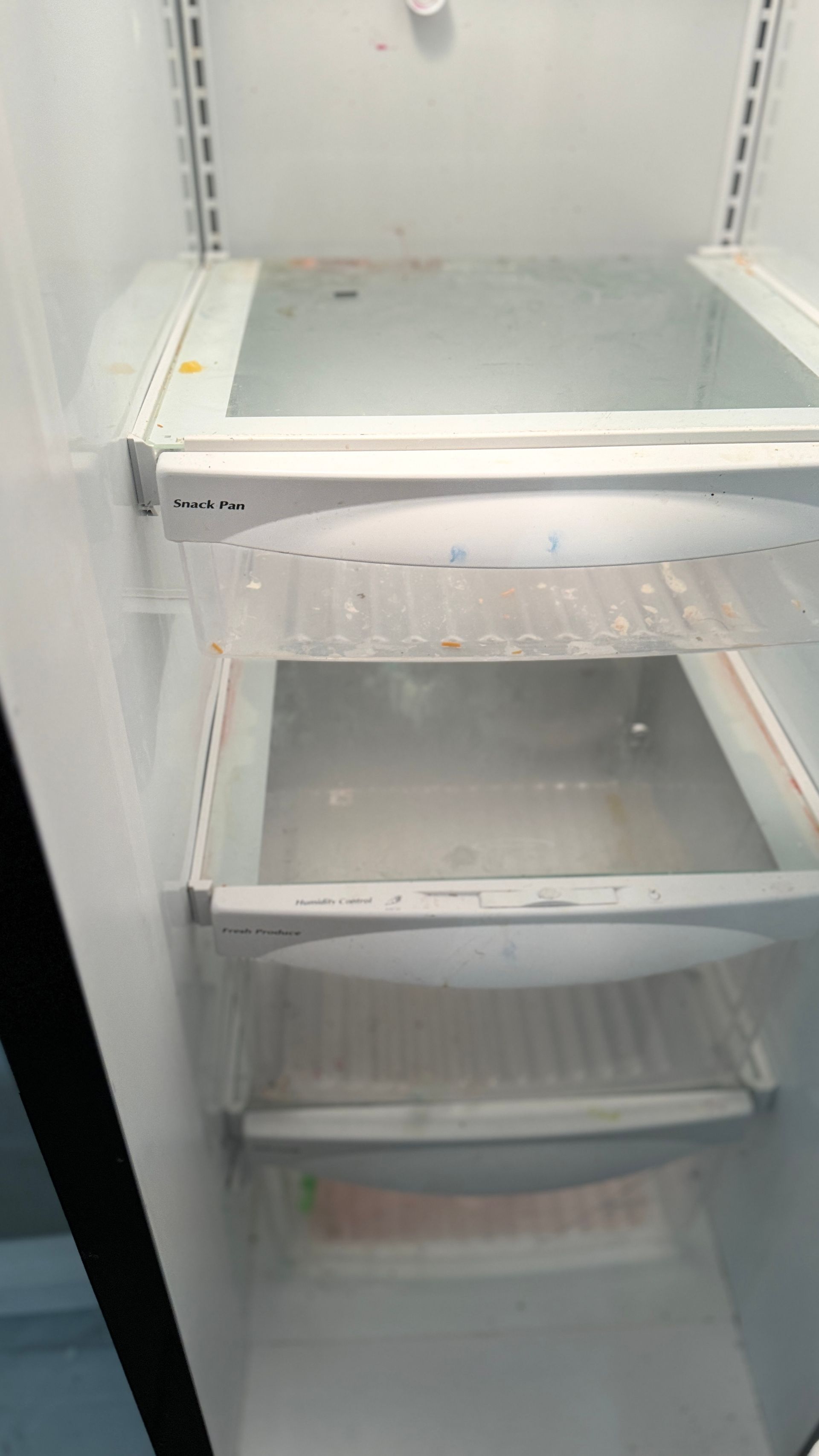 The inside of an empty refrigerator with the door open.