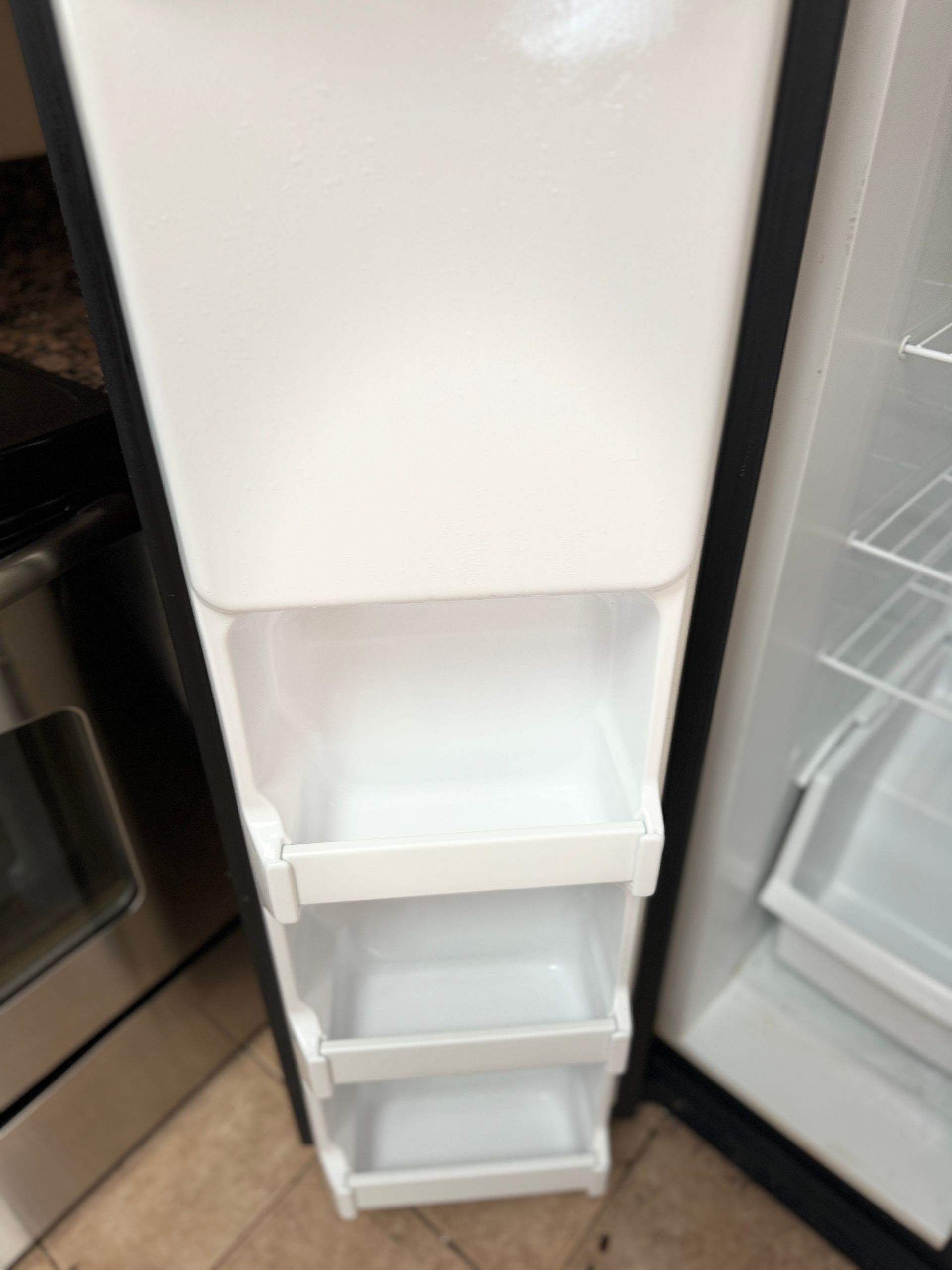 The inside of a refrigerator with empty shelves