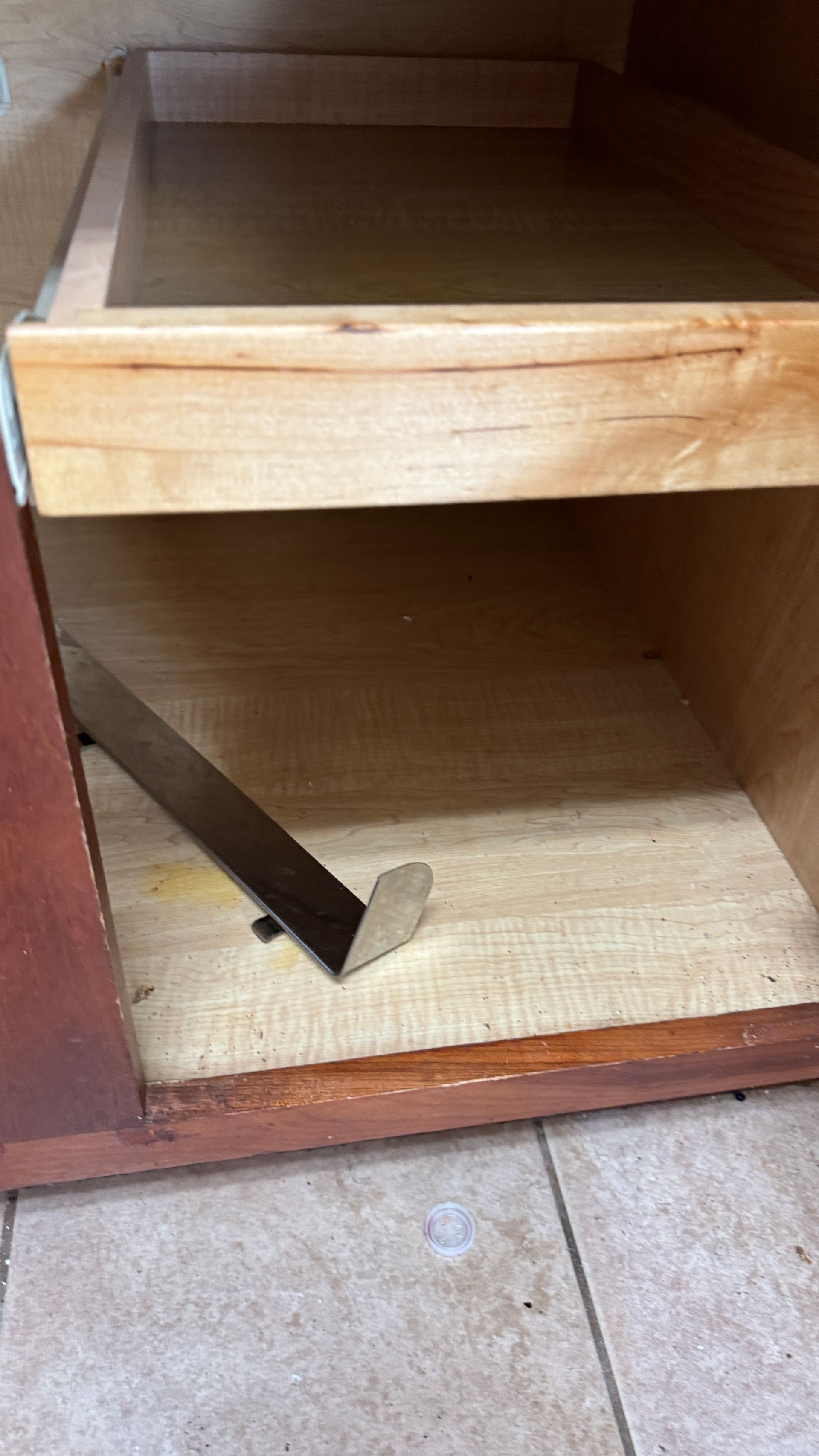 An empty wooden cabinet with a piece of wood sticking out of it.