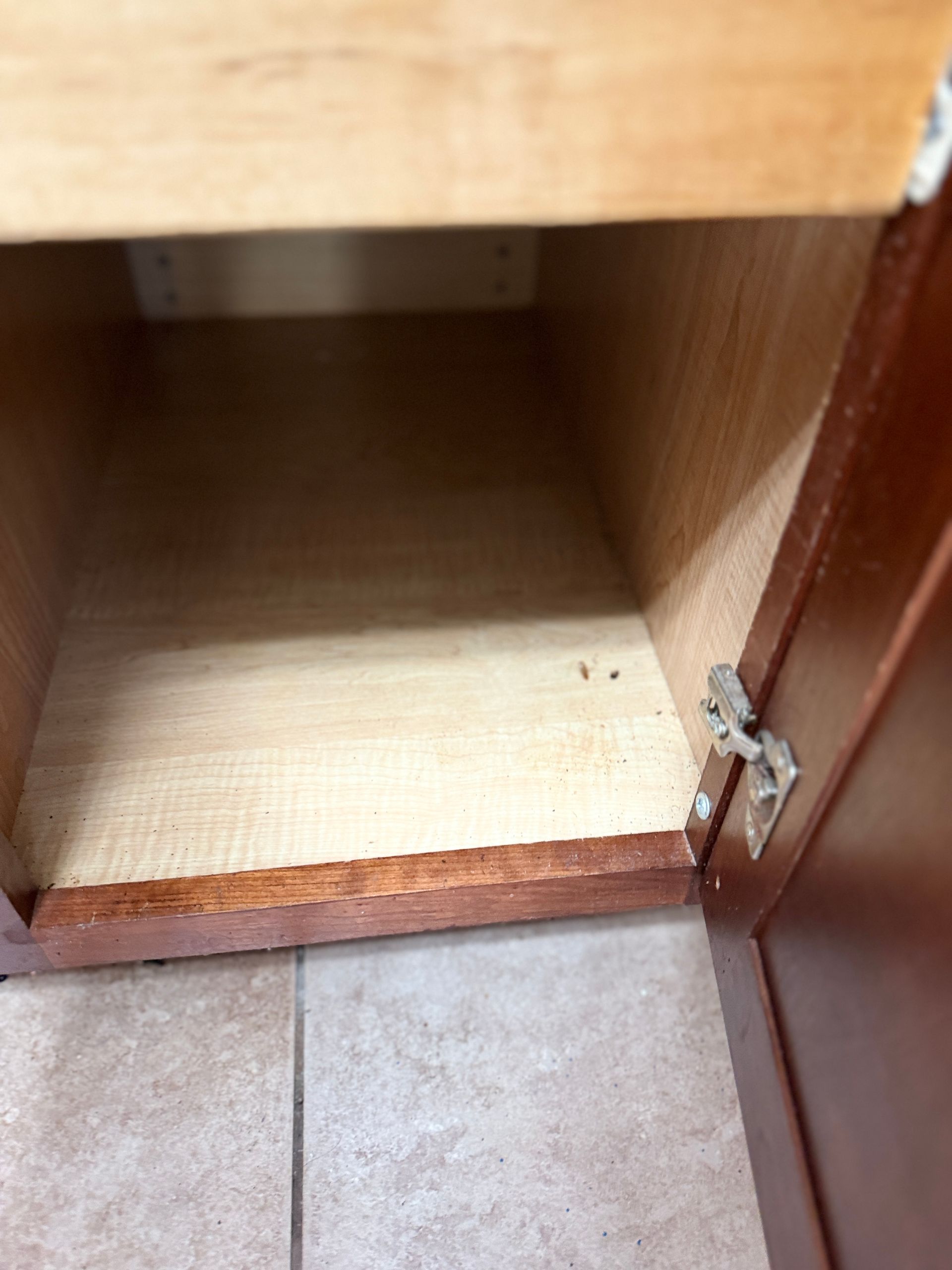 The inside of an empty cabinet with the door open.