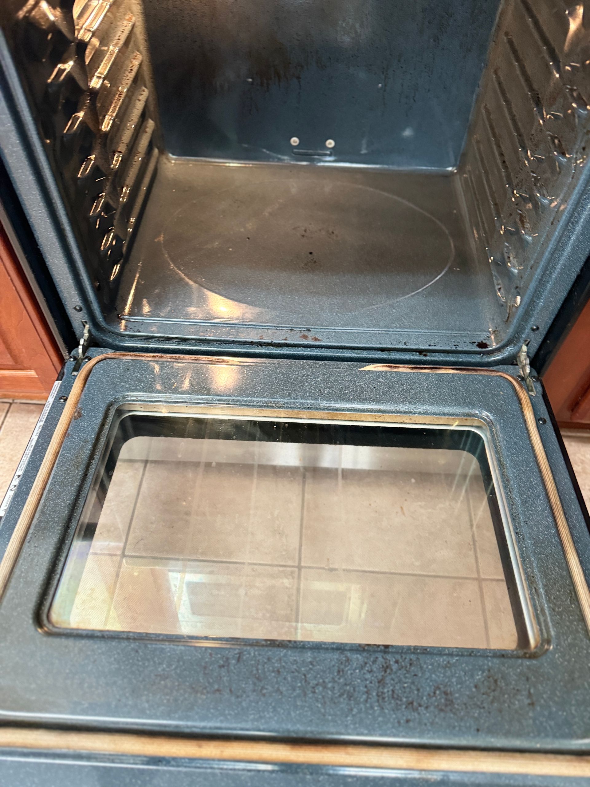 The inside of a dirty oven with the door open