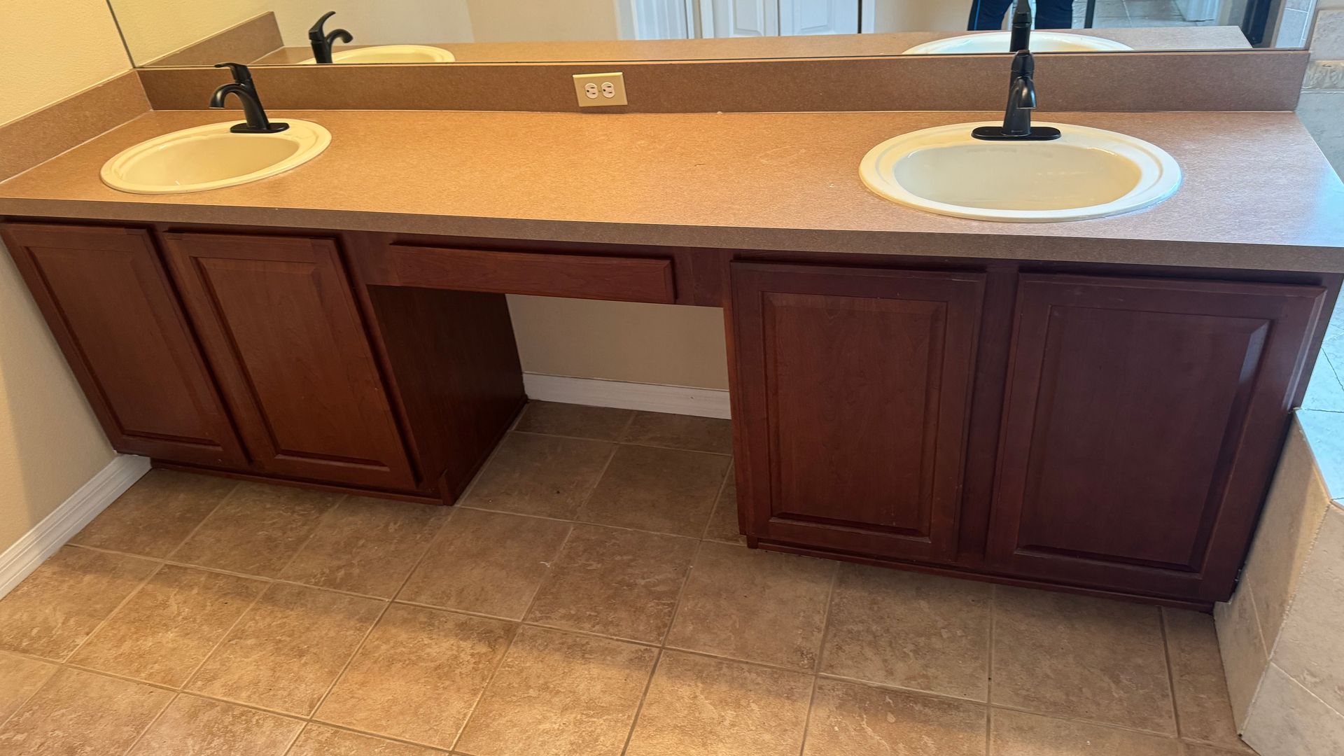 A bathroom with two sinks and a mirror.