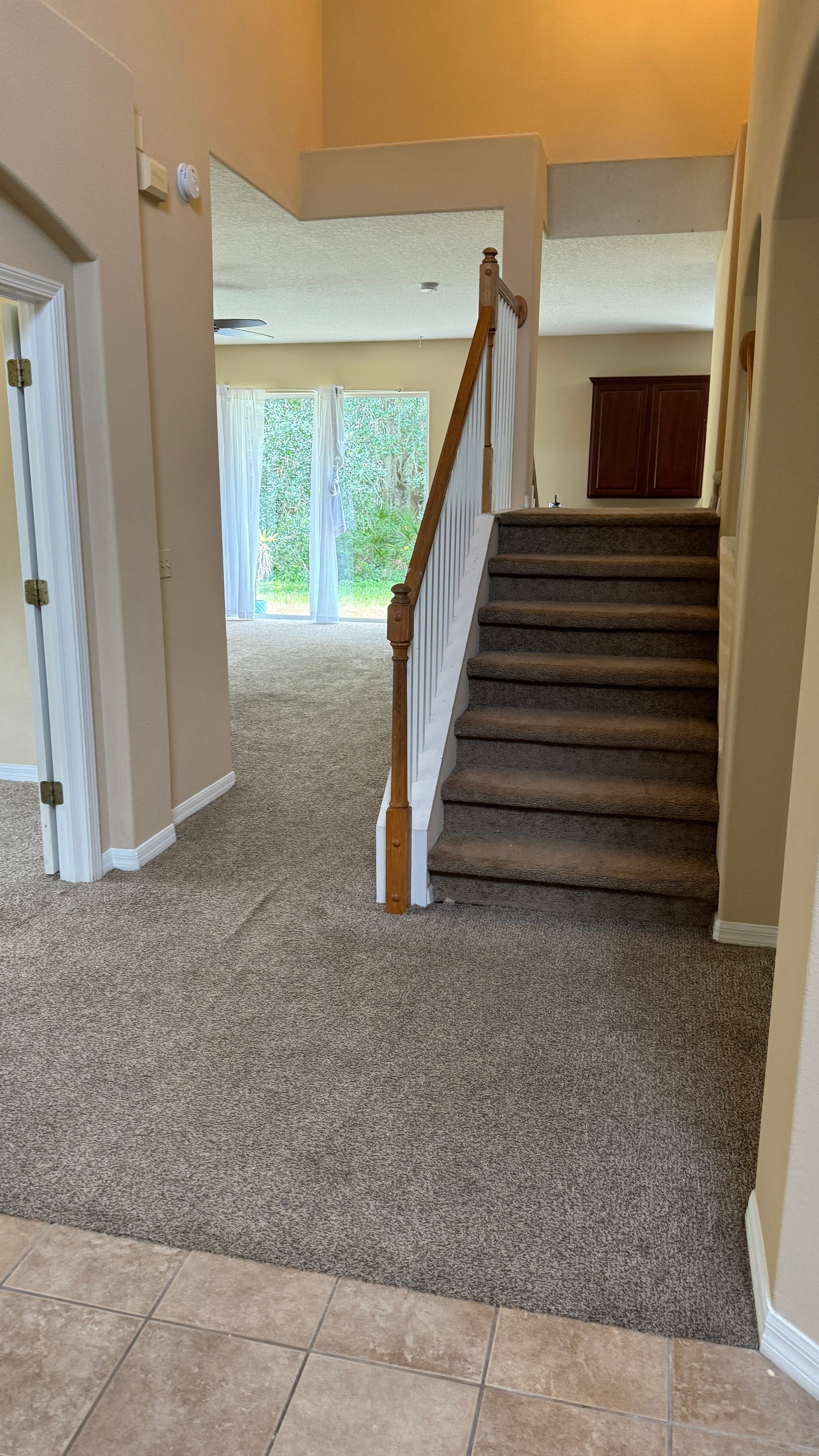 A staircase in a house with a carpeted floor and a wooden railing.