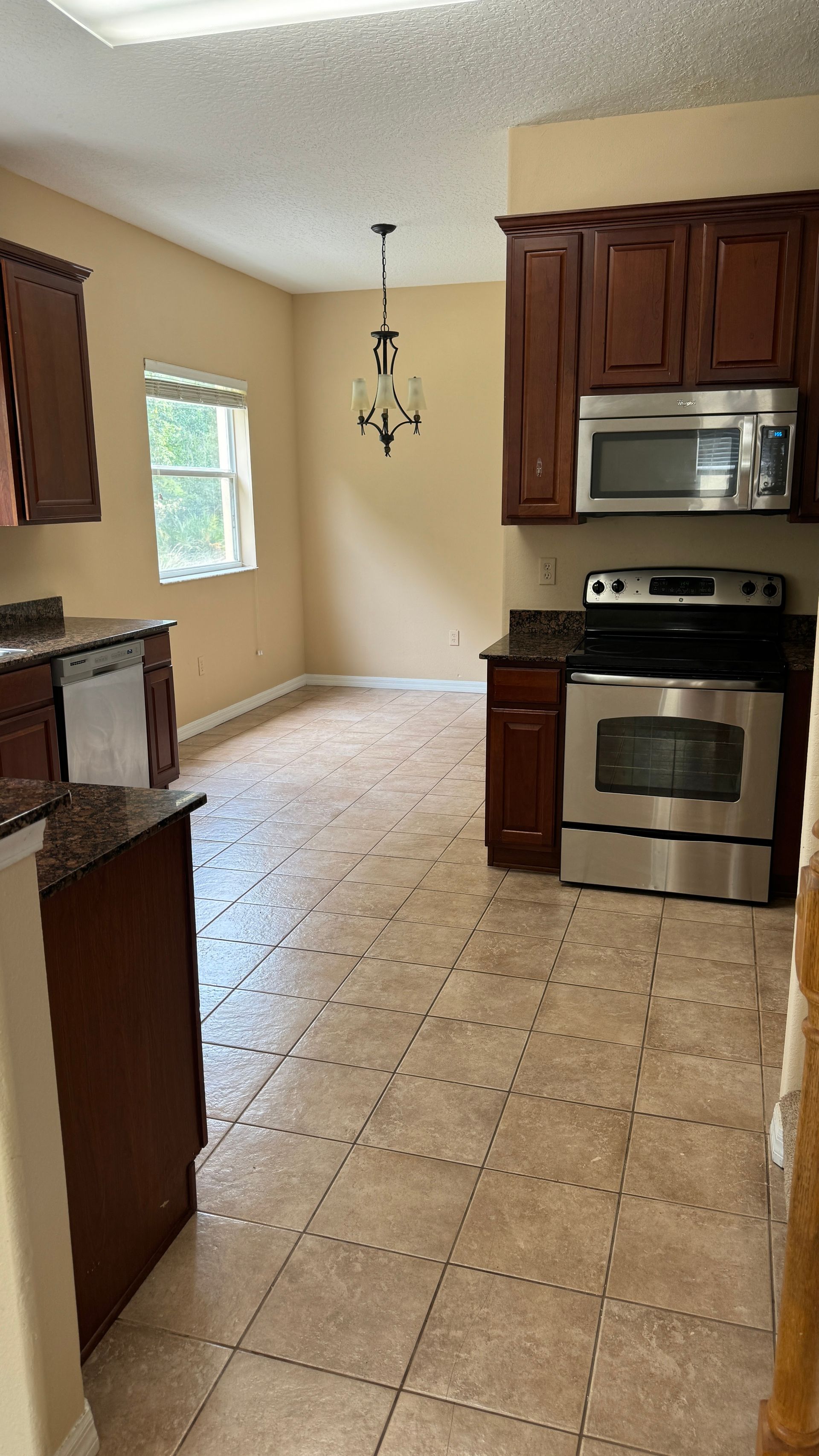 A kitchen with stainless steel appliances and wooden cabinets.