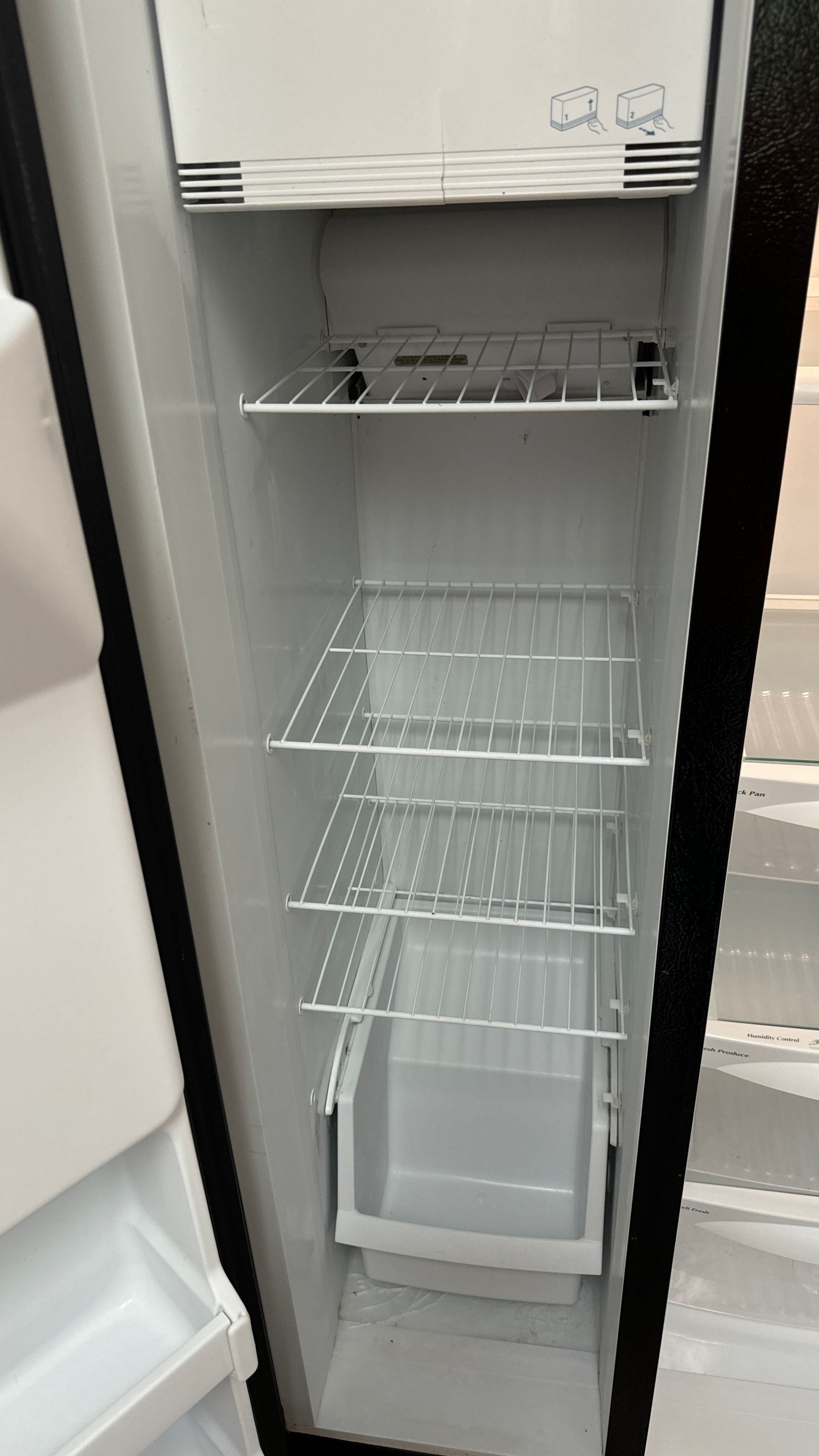 The inside of an empty refrigerator with shelves and drawers.
