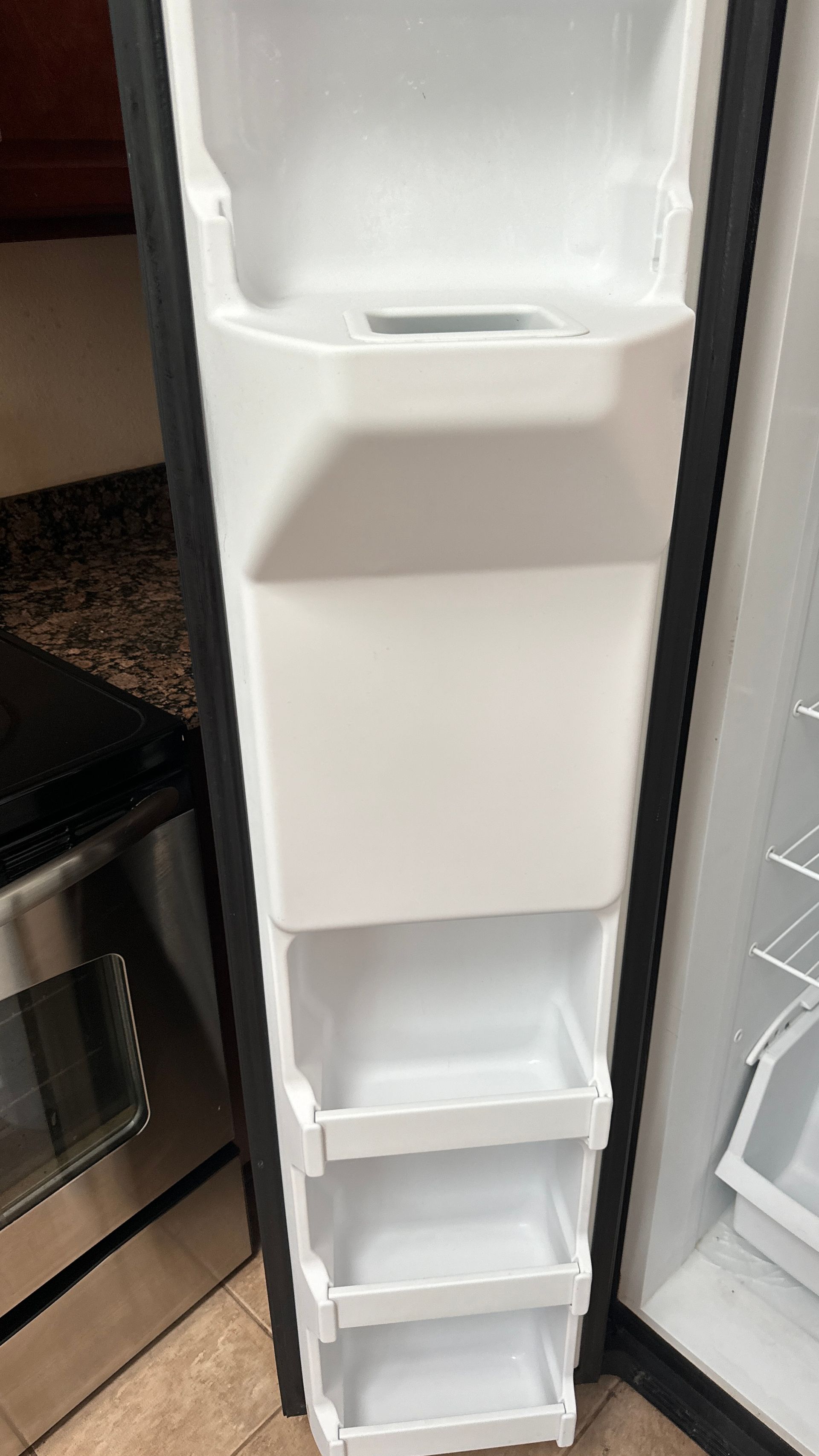 The inside of a refrigerator with the door open and empty shelves.