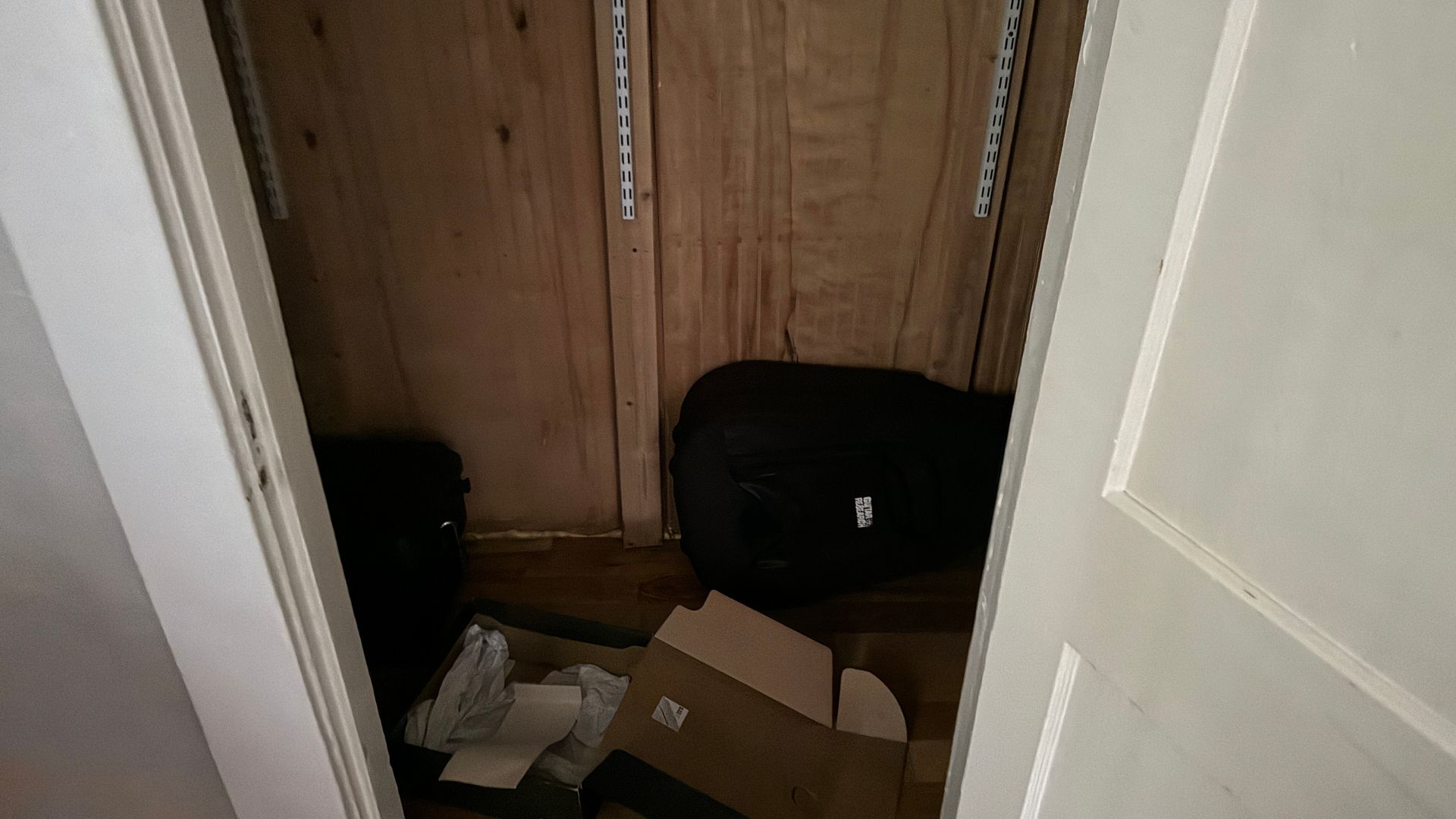 A closet filled with boxes and a suitcase.